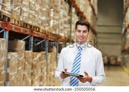 male manager man worker standing in big modern warehouse with tablet computer
