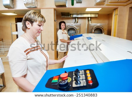 Hotel linen cleaning services. Woman with ironing machine working