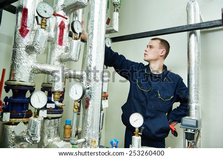repairman engineer or inspector of fire engineering system or heating system with valve equipment in a boiler house