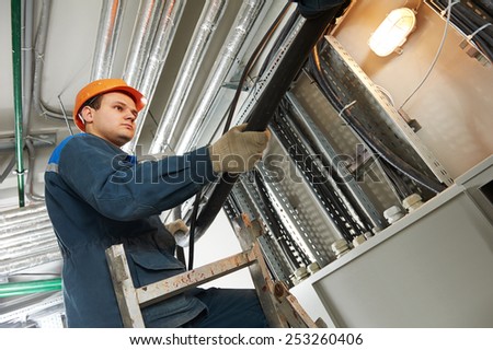 electrician builder engineer installing industrial cable into fuse box