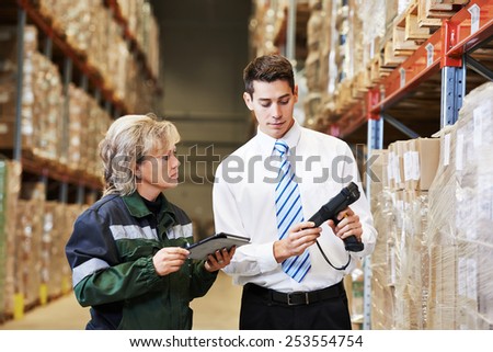manager and worker in warehouse with bar code scanner