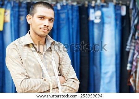 Portrait of one Indian tailor trade seller man with measure tape outdoors