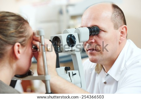 Optometry concept. Male optometrist optician doctor examines eyesight of female patient in eye ophthalmological clinic