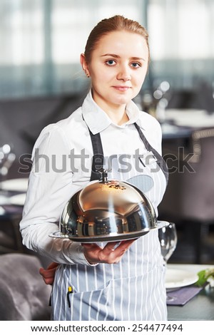 Waitress with tray and cloche at the indoor restaurant service