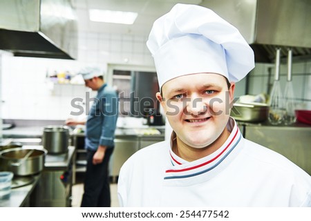 portrait of smiling male cook chef at restaurant kitchen