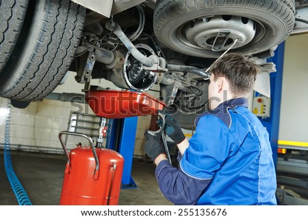 auto repairman mechanic works with rear axle reduction gear of commercial van in car auto repair or maintenance shop service station