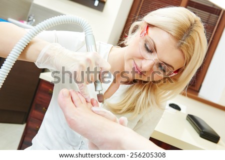 Pedicure nail technician worker perfoming procedure for foot care in beauty salon