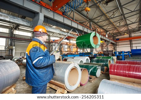 industrial worker operating metal sheet profiling mechine at manufacturing factory