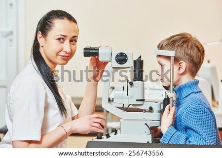 Optometry concept. Female optometrist optician doctor examines eyesight of child boy in eye ophthalmological clinic