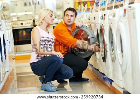 Young man choosing washing machine in home appliance shopping mall supermarket