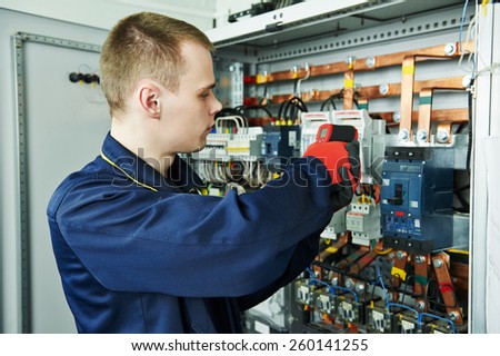 electrician inspector cheching power of fuseboard equipment in boiler room