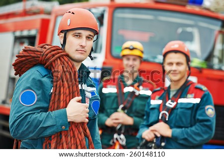 firefighters team in uniform in front of fire engine machine and fireman team