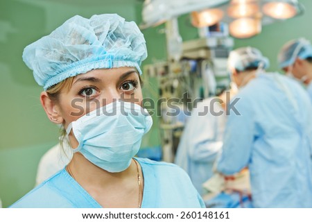 surgeon assistant nurse in uniform during heart transplantation operation on a patient at cardiac surgery clinic
