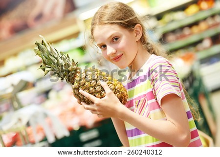 child girl during shopping with pineapple fruit at supermarket