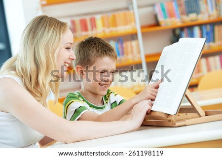 Family education. Mother woman and child boy in library reading books