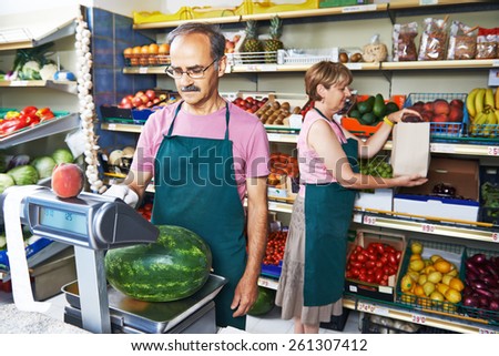 adult senior sale man with assistant in fruit vegetable market shopping store