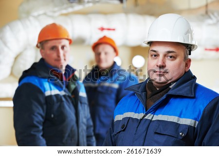 three repairman engineer of fire engineering system or heating system open the valve equipment in a boiler house