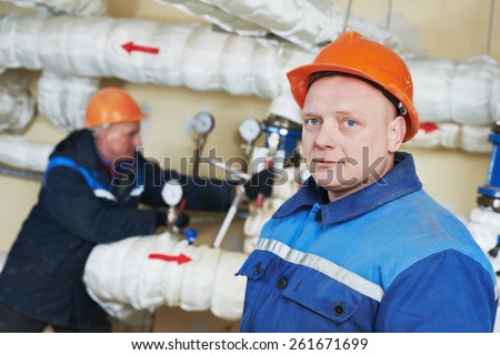 two repairman engineer of fire engineering system or heating system open the valve equipment in a boiler house