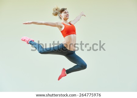 fitness instructor jumping during aerobics dancing exercises in sport club