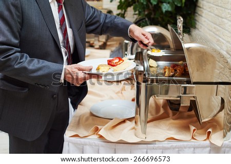 restaurant catering service. Man with food at morning buffet style smorgasbord