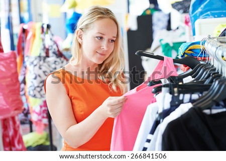 woman choosing dress during shopping at garments apparel clothing shop