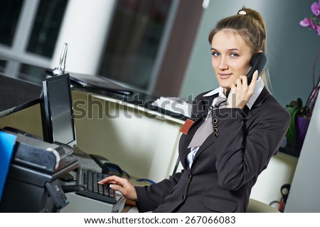 female manager worker assistant speakiong on phone at hotel reception