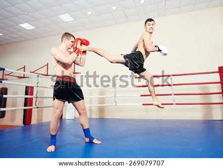 muai thai sportsman fighting at training boxing ring