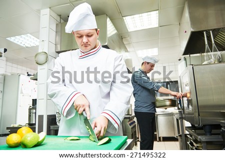 cooks chef in uniform cooking at restaurant kitchen