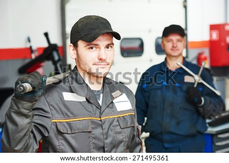 Two repairmans auto mechanic portrait in car auto repair or maintenance shop service station