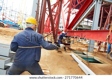 builder worker at construction site installing metal construction frames