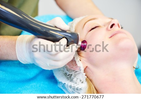 Young woman under laser therapy cosmetology procedure