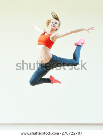fitness instructor jumping during aerobics dancing exercises in sport club