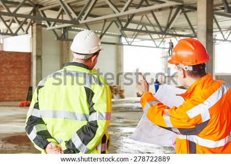 male engineers construction foreman managers outdoors at building site with blueprints