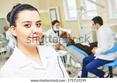 A portrait of a iranian muslim female dental assistant or doctor smiling the dentist working in the background