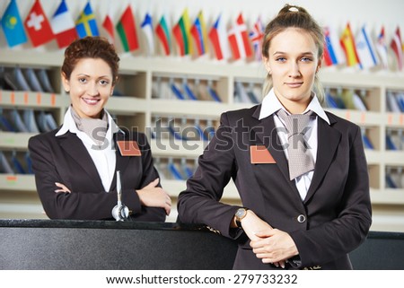 Happy female receptionist worker standing at hotel counter