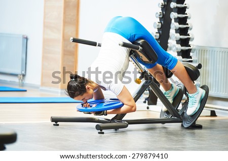 Hyperextension. fitness and sport concept. personal coach trainer woman work out at a gym with heavy weight