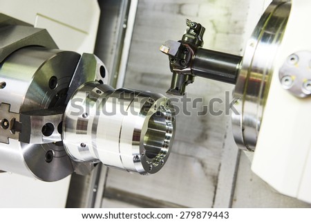 metalworking  industry: multi cutting tool pefroming facing cut of metal detail on lathe machine in workshop