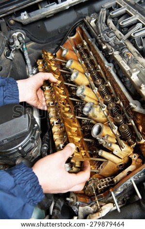 mechanic repairman hands with shaft over automobile car engine maintenance repair work