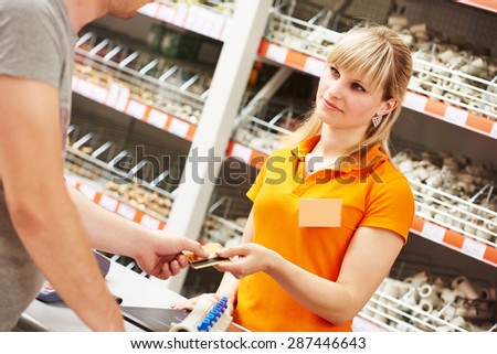 Hardwarre seller or sale assistant cashier accepting credit card as payment for purchase
