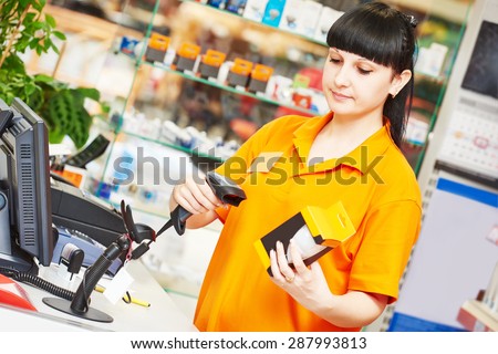 female seller with bar code scanner scanning lamp at store