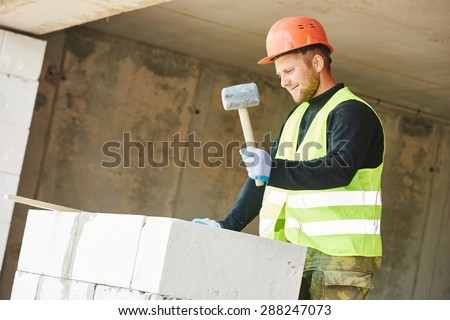 Bricklaying work. construction worker mason bricklayer installing calcium silicate brick