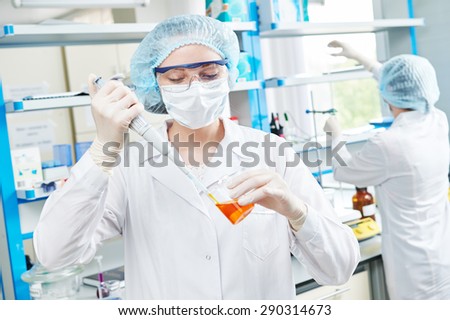 science laboratory work. female scientific researcher or doctor holding flask with pink liquid solution