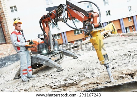 builder worker in safety protective equipment operating construction demolition machine robot. Focus on tool