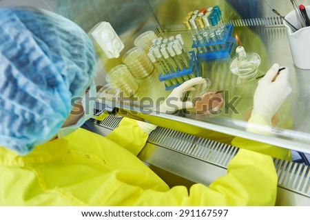 female science researcher in protective uniform and equipment works with dangerous hazard virus material at microbilogy laboratory