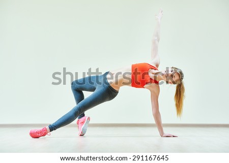 fitness instructor doing pilates or dancing exercises in sport club