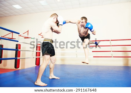 muai thai sportsman fighting at training boxing ring