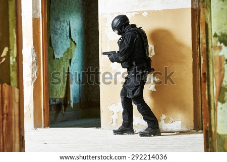 Military industry. Special forces or anti-terrorist police soldier,  private military contractor armed with pistol ready to attack during clean-up operation, mission