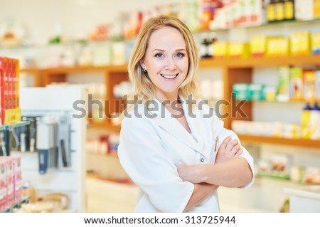 portrait of cheerful smiling female pharmacist chemist woman in pharmacy drugstore