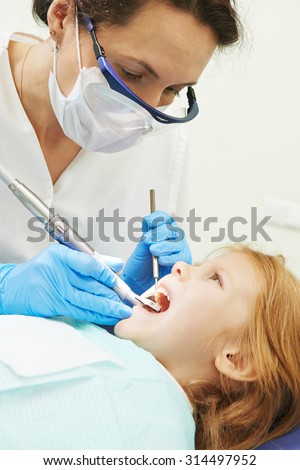 dentist orthodontist female doctor making dental care to child patient at working place