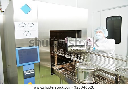 pharmaceutical factory woman worker operating autoclave for medicine drug steam sterilization at pharmacy industry manufacture factory